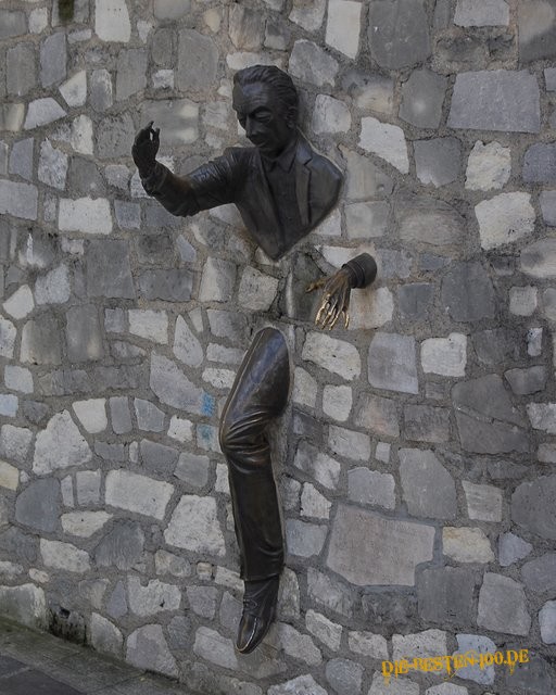 Mann kommt aus Wand - Skulptur aus Bronze