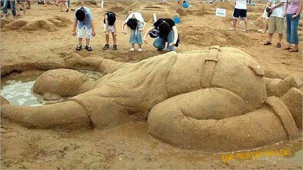 Sand-Figur steckt Kopf in Sand